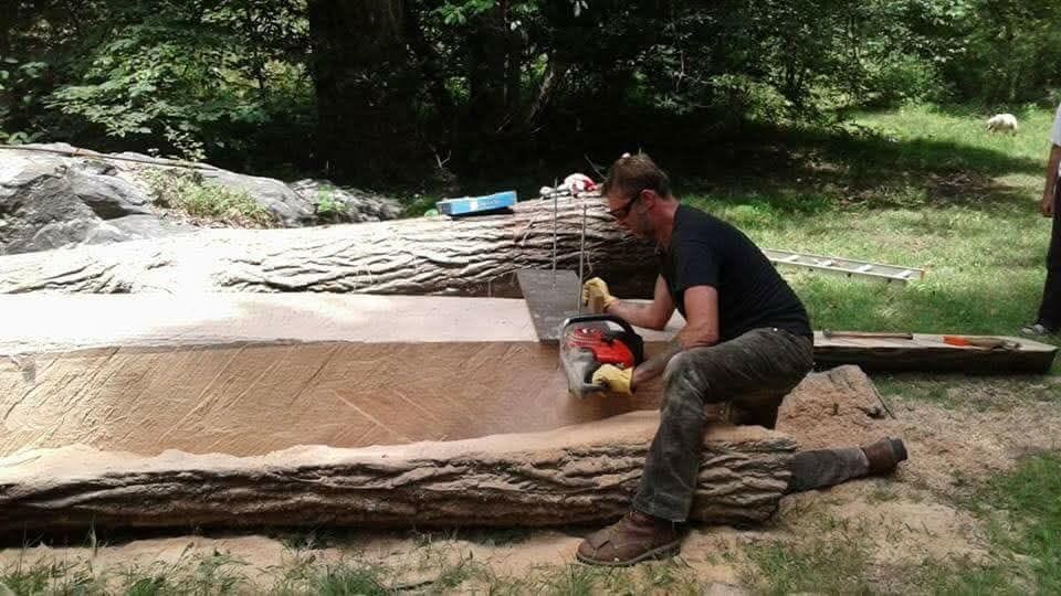 Nute cutting a large log with a chainsaw